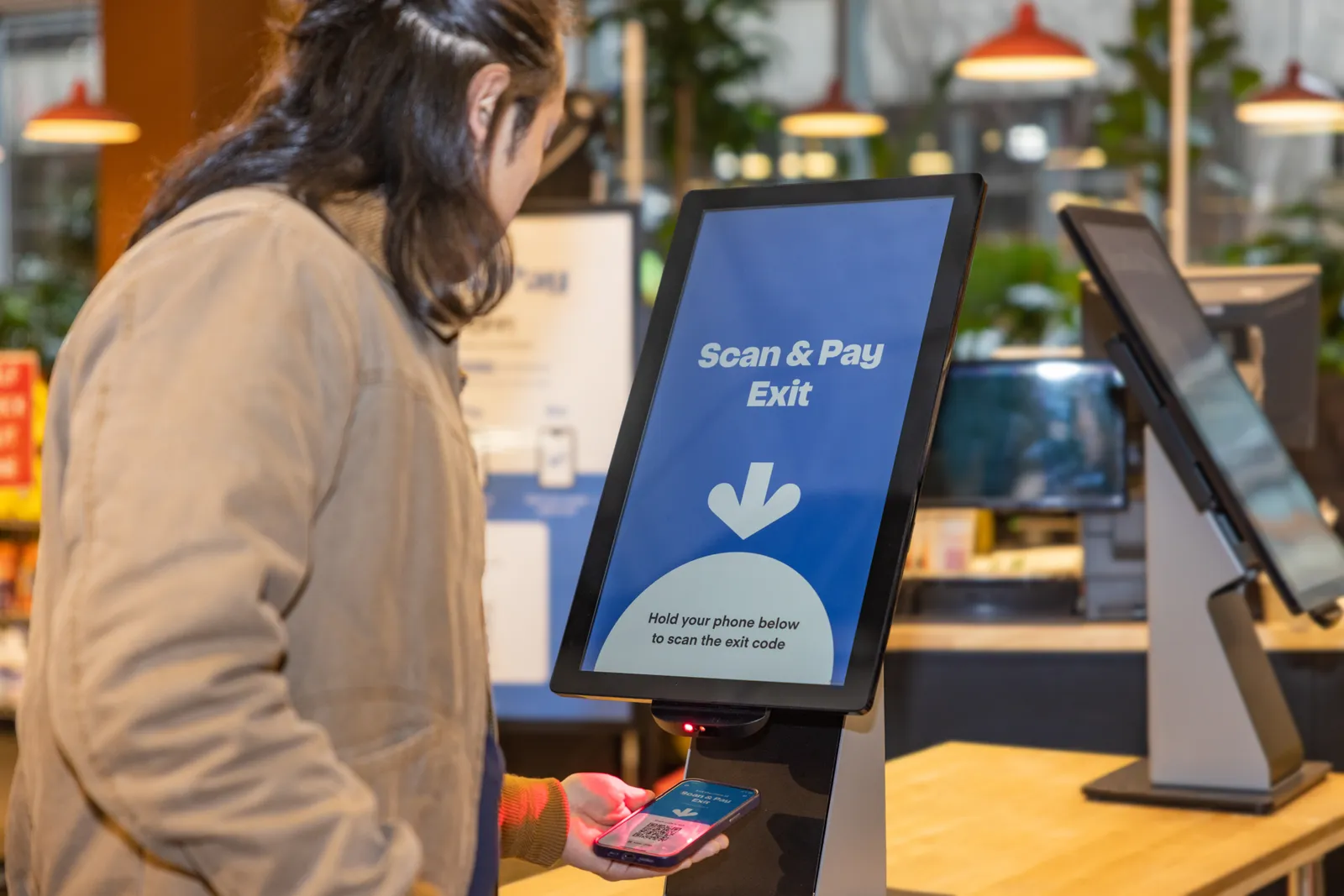 A customer using scan and pay at a grocery store.