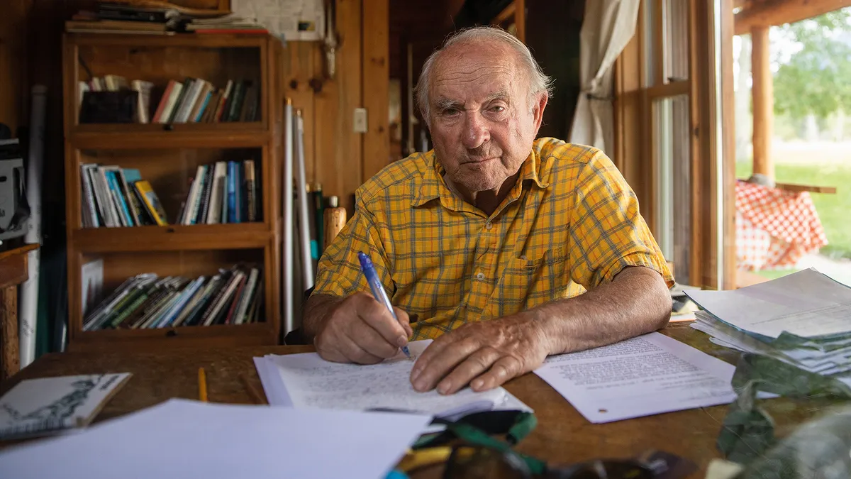 Patagonia's founder Yvon Chouinard sits at a desk writing.