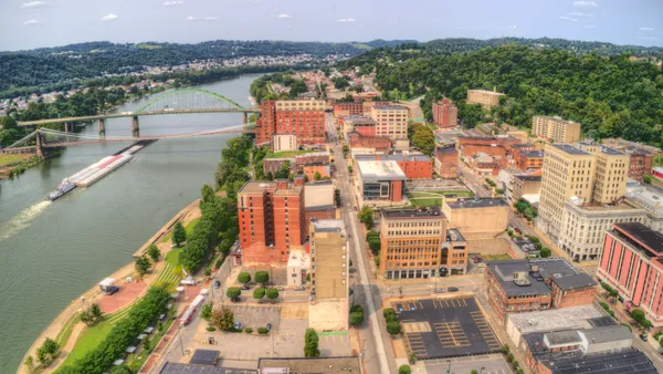 An aerial shot of Wheeling, West Virginia shows buildings, a river and a bridge