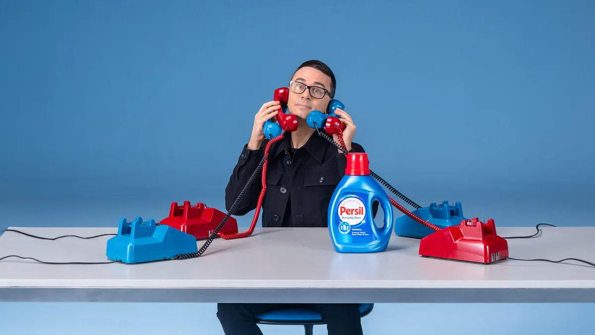 Persil laundry detergent teams with fashion designer Christian Siriano, shown in the photo holding a phone to his ear, to launch a 24-hour Wardrobe Refresh Hotline on TikTok Live.