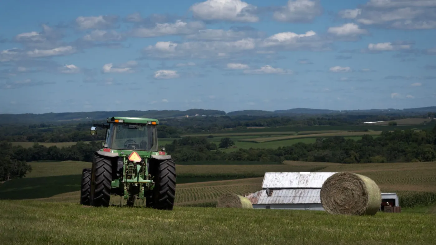 A tractor moves through a farm field