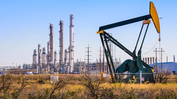 Pumpjack (oil derrick) and refinery plant in West Texas.