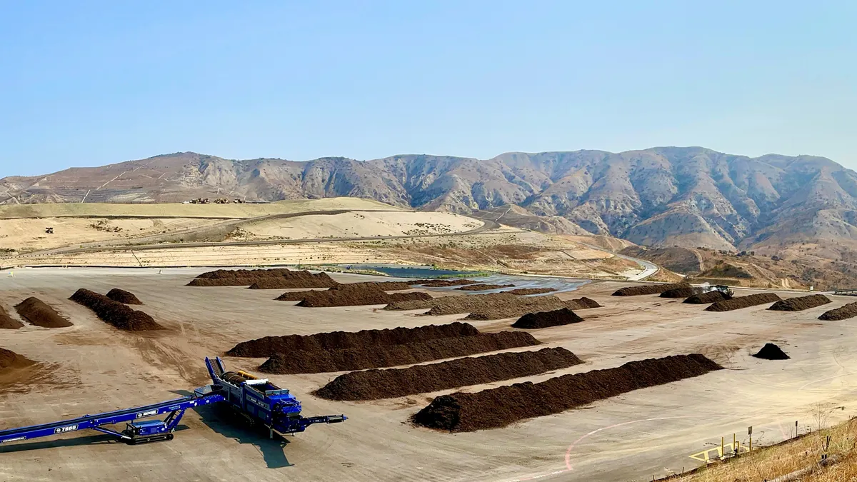 Aerial view of composting operations at a landfill in Orange County, California with mountains in the background