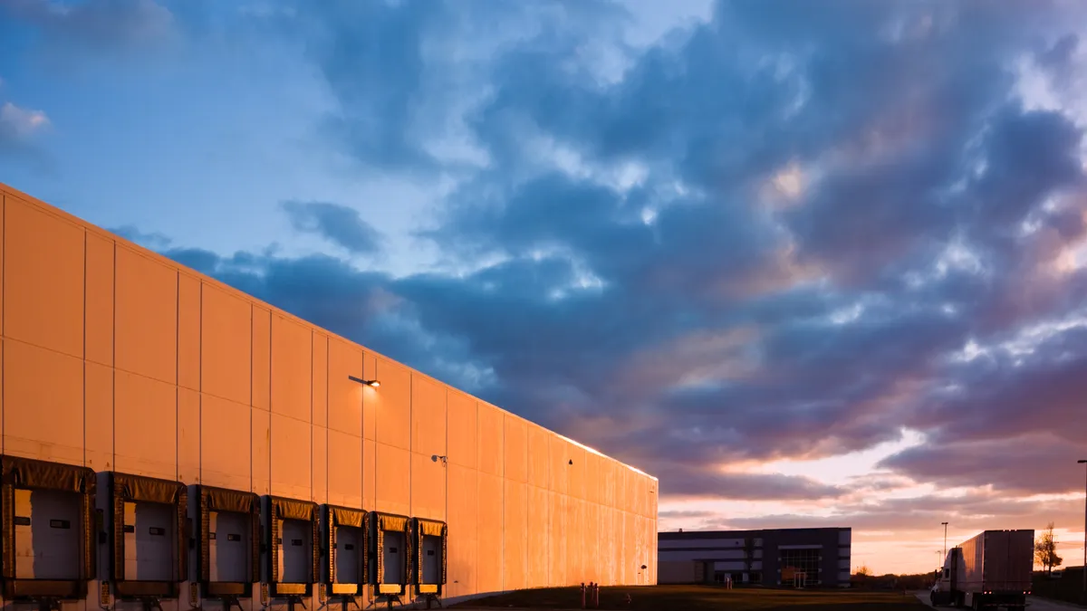 External shot of warehouse with clouds in the background.