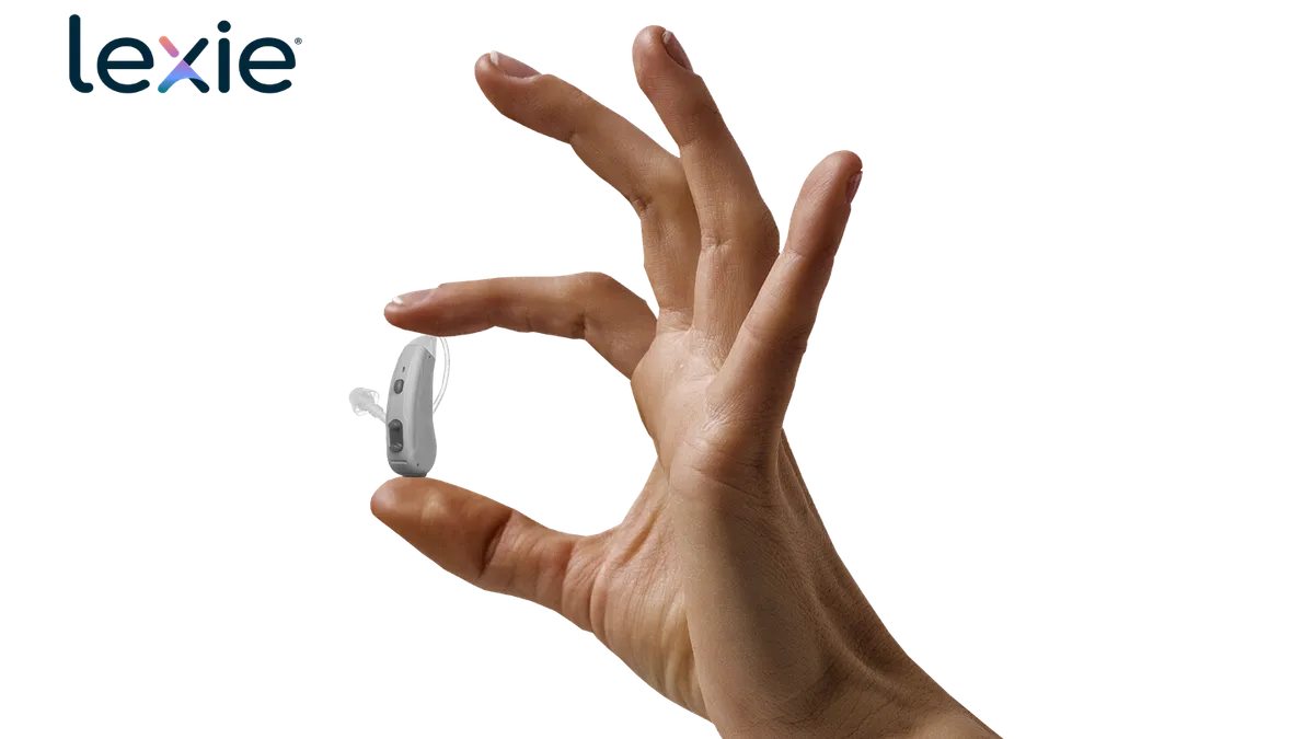 A lexie/Bose OTC hearing aid held in a person's hand