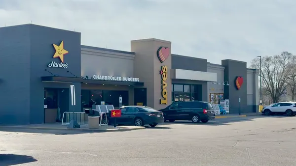 A photo of the exterior of a store. Signs on the side of the building says "Love's," "Hardees" and "Charbroiled burgers."