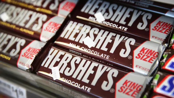 A row of king-sized Hershey chocolate bars sit on the shelf in a store.