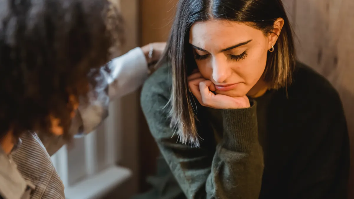 A woman is comforted by another woman.