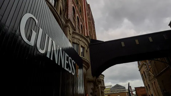 A gate that reads Guinness in front of the brewery.