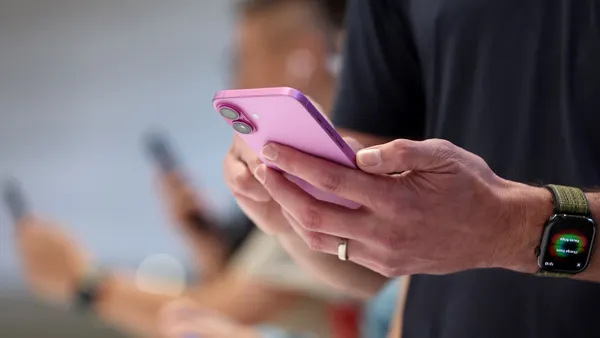 Close up of a a person holding a smartphone.