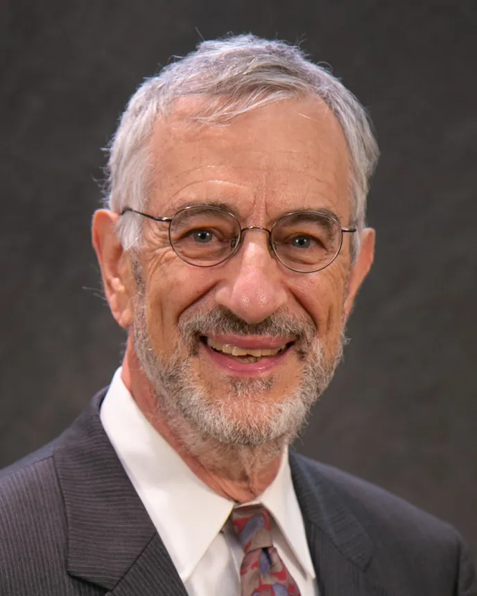 Headshot of a man with silver hair.