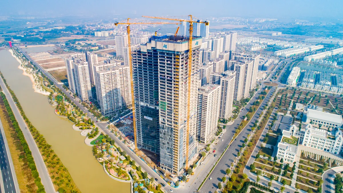 Yellow cranes tower over the Vinfast office building in Hanoi, Vietnam.