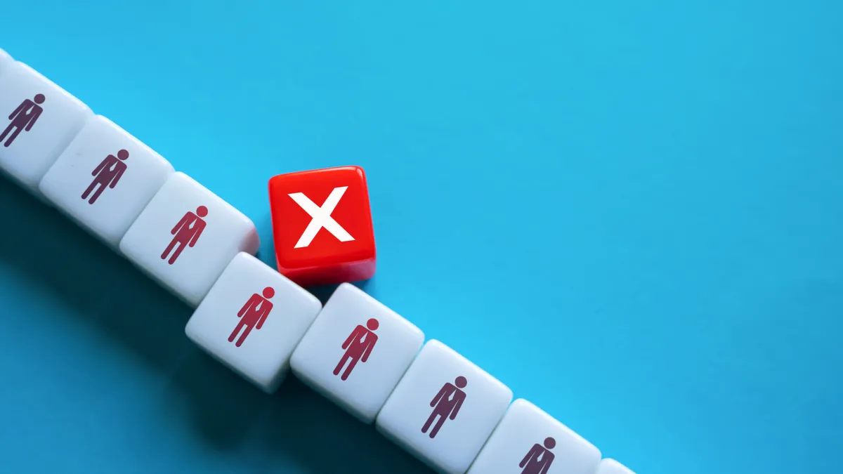 A stock photo of blocks arranged to illustrate layoffs
