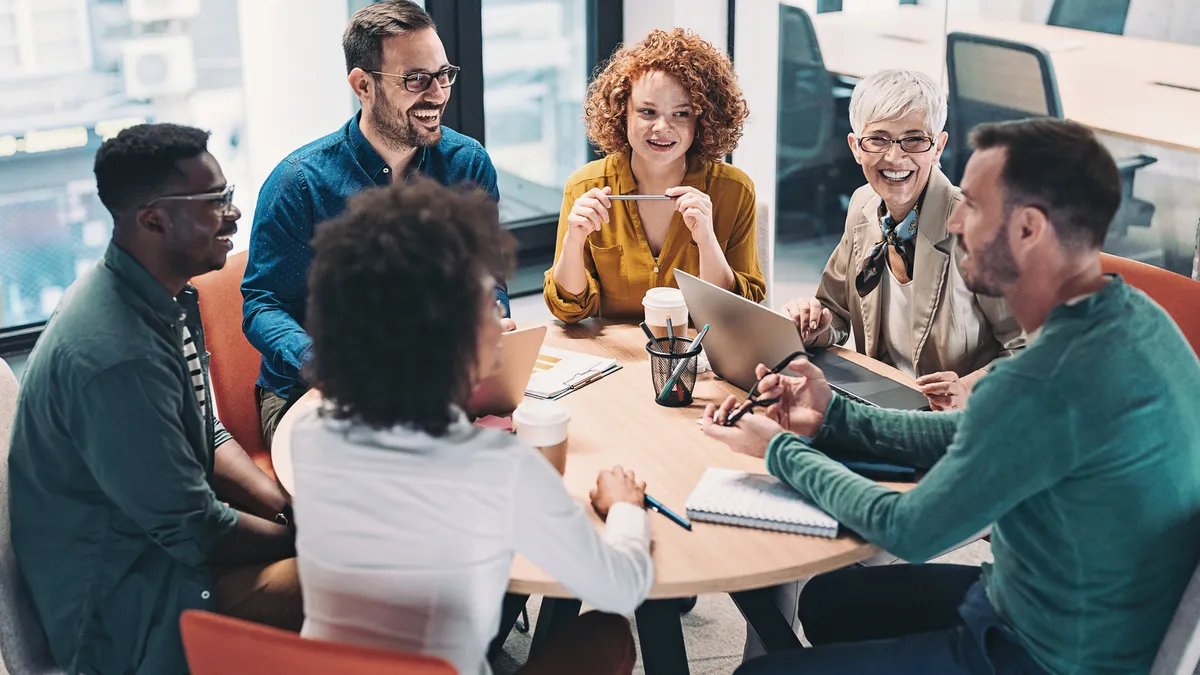 A group of business people sitting around a table and talking