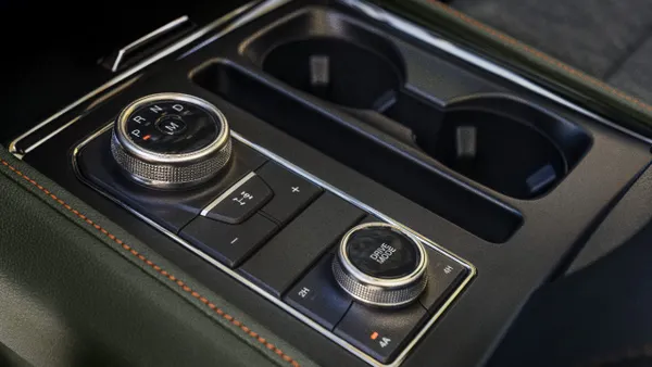 The center console in a 2022 Ford Expedition Timberline SUV showing the shift knob and cup holders.