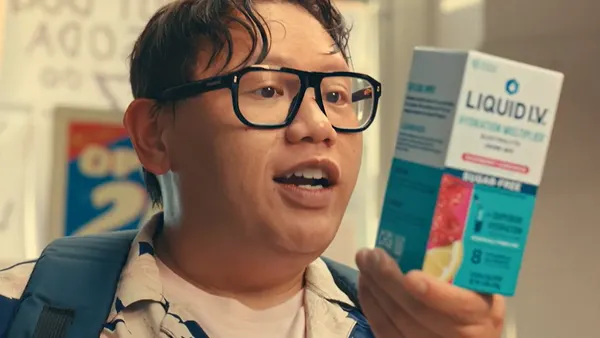 Actor Jacob Batalon, playing Ned Leeds from the "Spider-Man" franchise, holds up a box of Liquid I.V. product