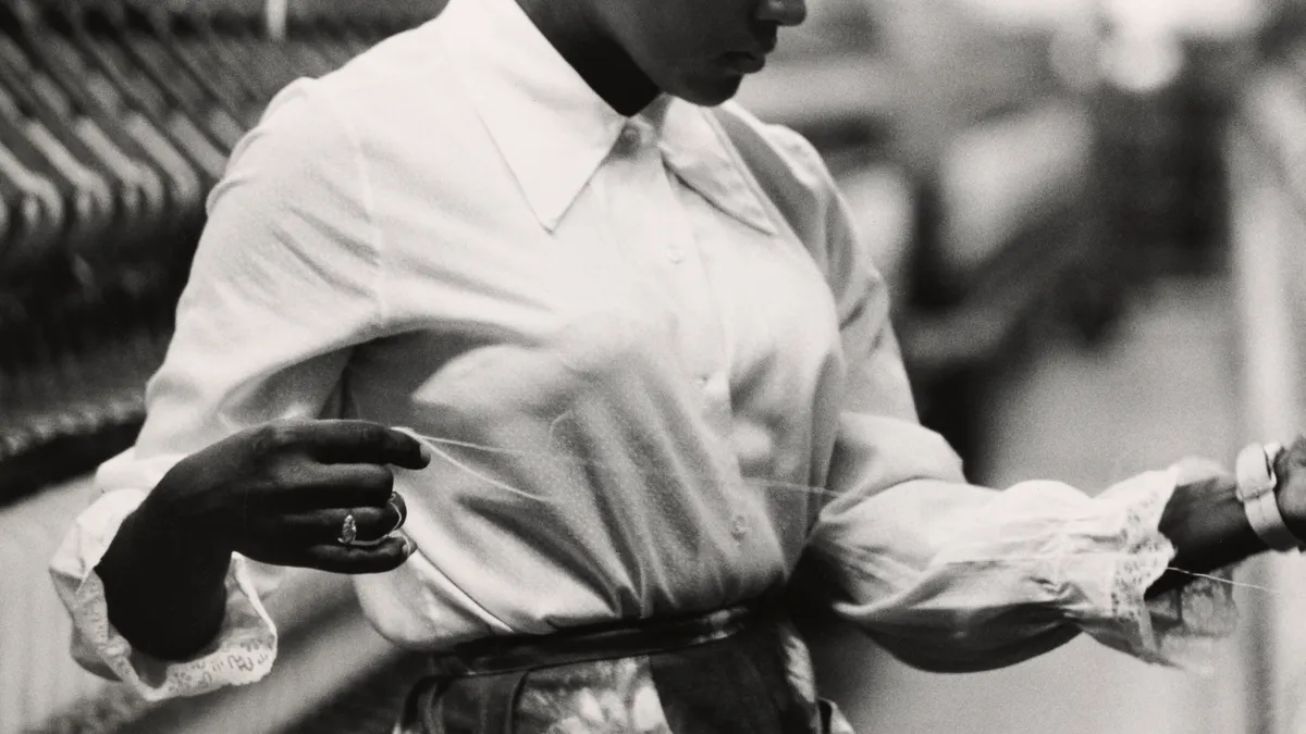 A Black woman works on a loom in a textile mill, North Carolina, circa 1960.