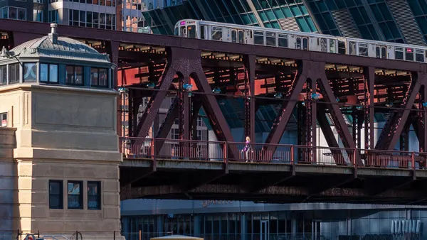 A wide shot from a distance of a metal bridge that stretches across the image.