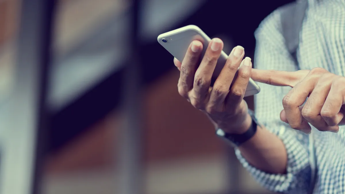 Person's hands holding a cellphone