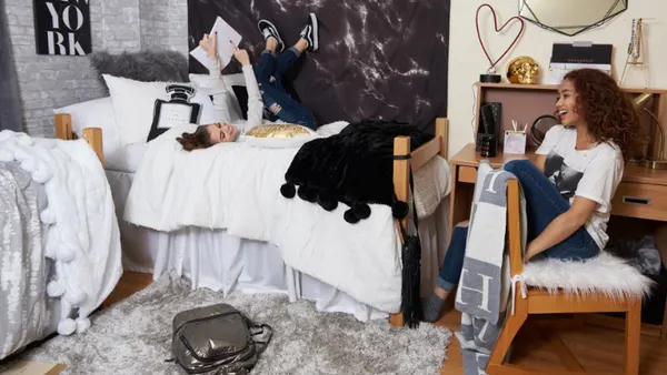 Two people sitting in a dorm room