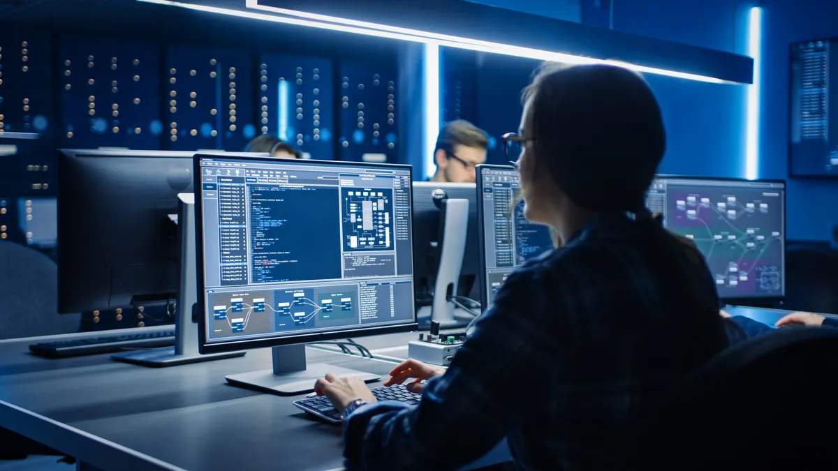 IT Programer Working on Desktop Computer in Data Center System Control Room