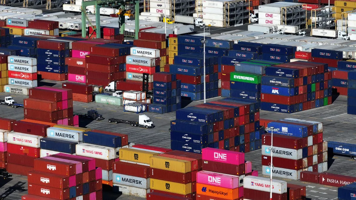 In an aerial view, shipping containers are stacked on a dock at the Port of Oakland on December 09, 2024 in Oakland, California.