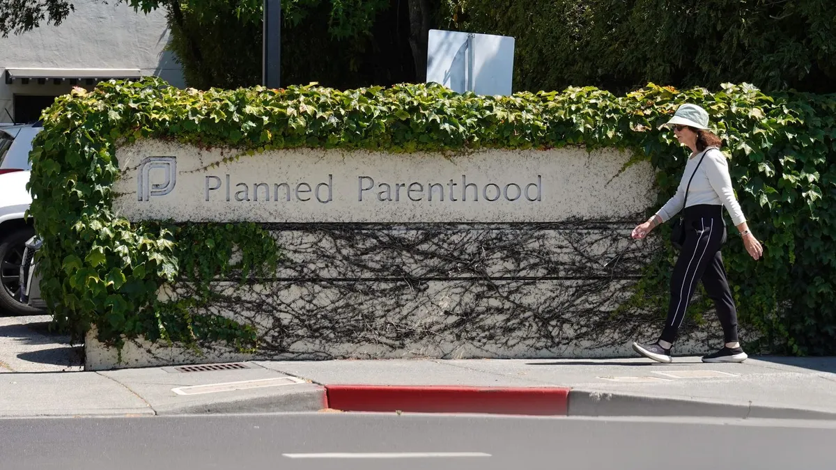 A woman walks in front of a sign by a Planned Parenthood health center on June 26, 2025 in San Rafael, California.