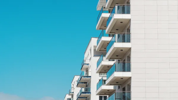 The exterior of a white hotel building with balconies.