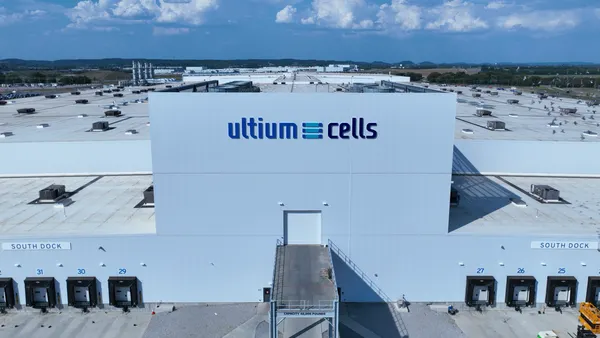 An aerial view of the  Ultium Cells battery plant in Tennessee show the company logo on the wall and numbered docking bays for trucks.