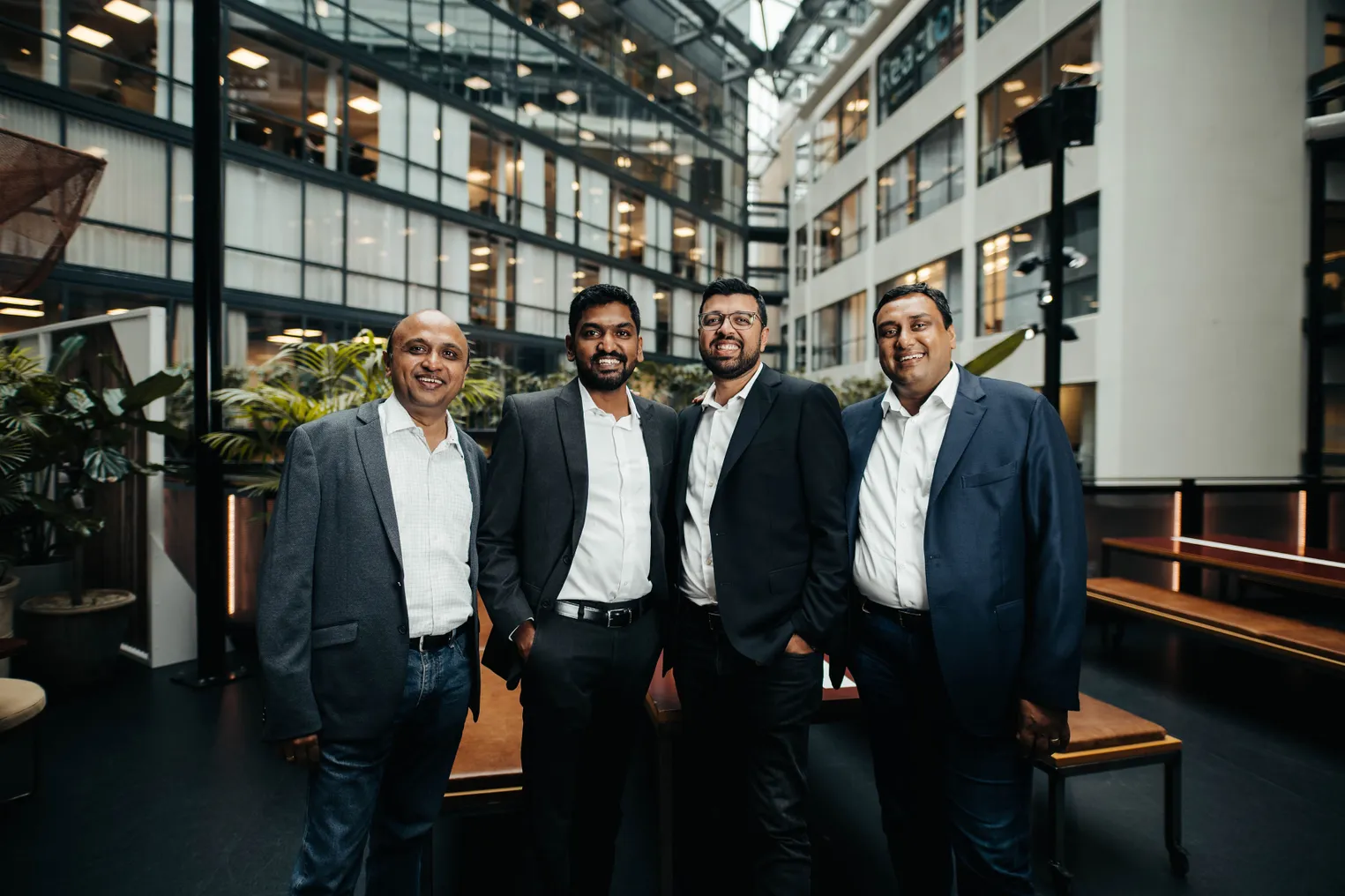 Four people stand for a professional headshot.