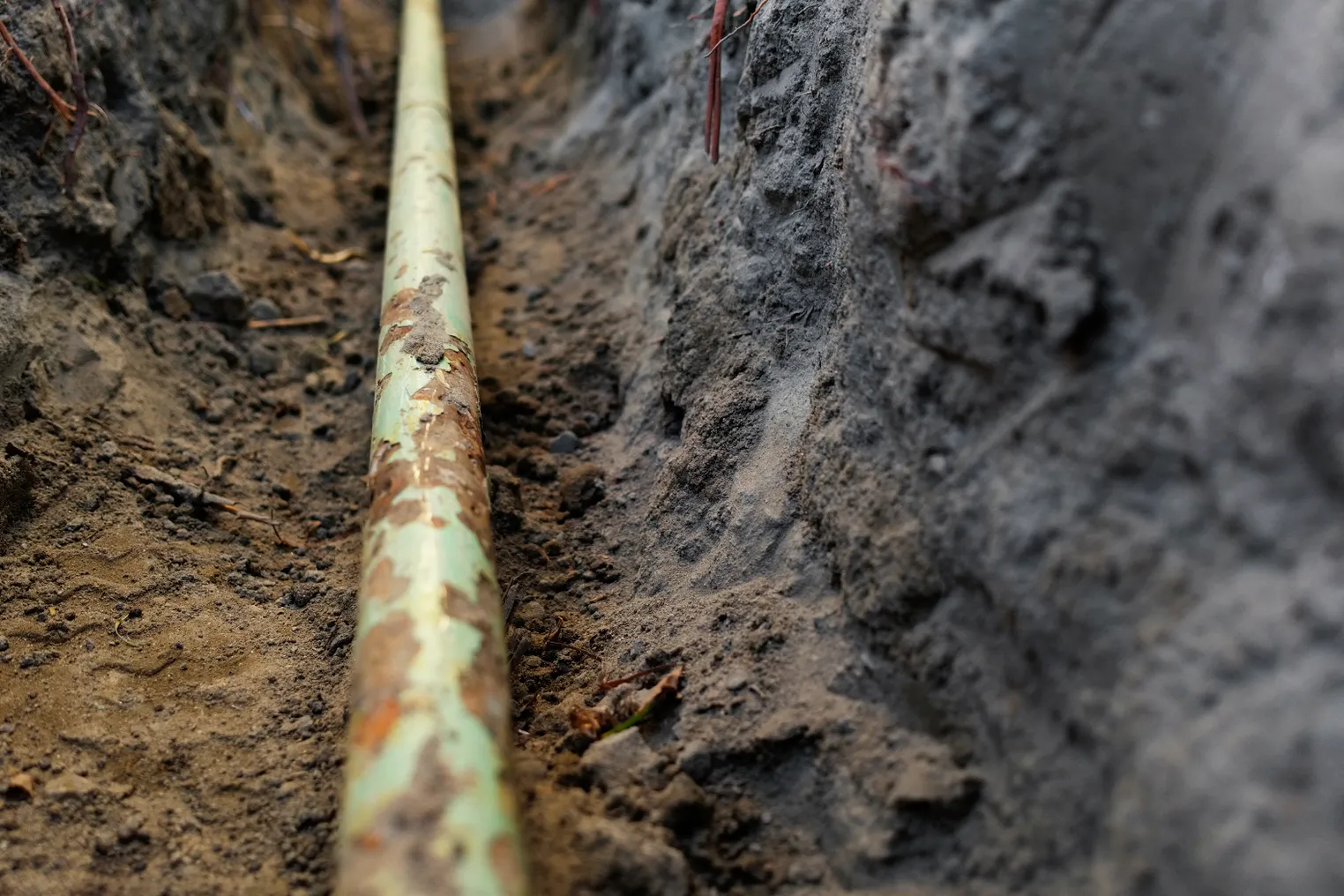 Close-up of a pipeline in a trench dug in the ground