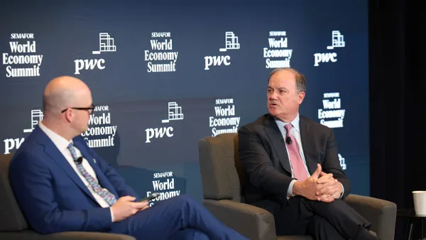 Tim McDonnell of Semafor, left, and Bob Frenzel, chairman, president and CEO of Xcel Energy, right, speak on stage