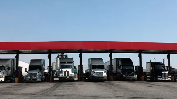 Trucks at fueling stations at a truck stop on a sunny day.
