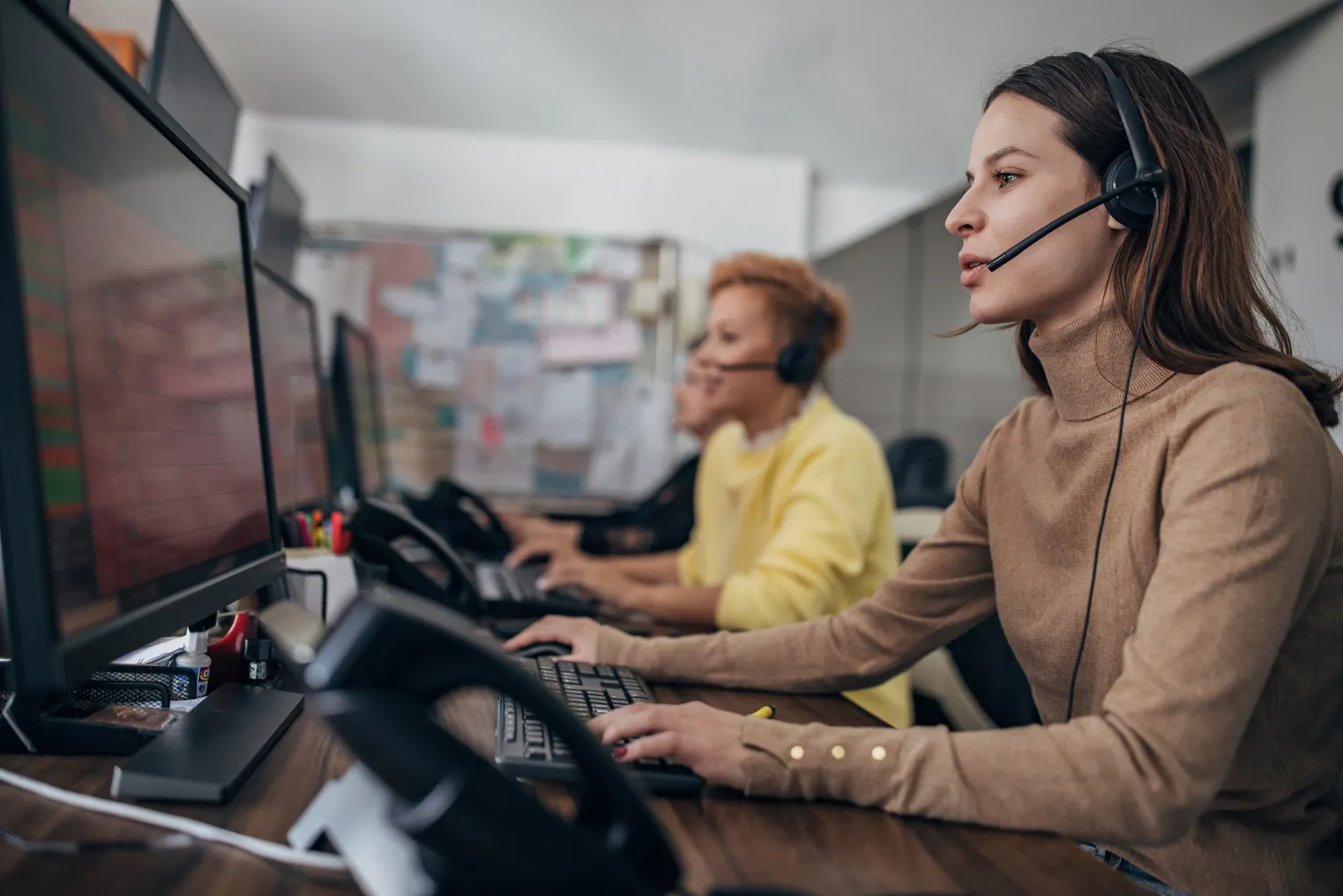 A woman in a call center answers a call.