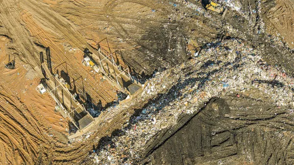 Aerial view of a municipal waste landfill in Pennsylvania shows two large bulldozers organizing the garbage into separate rows.
