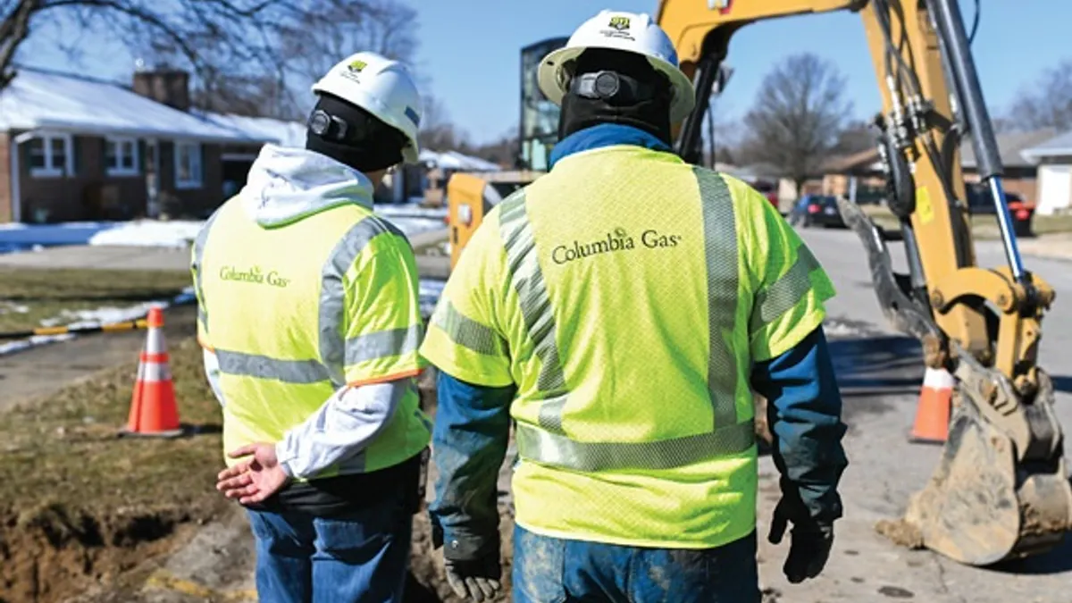 Men look at gas pipeline work.