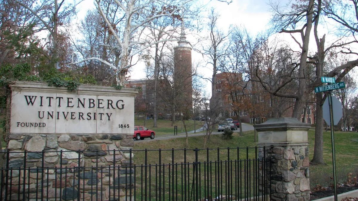 View of a 'Wittenberg University' sign and campus buildings from street.