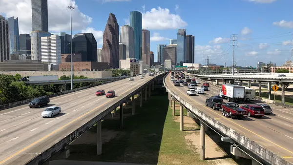 Three separate elevated highways lead to the Houston skyline in the background.