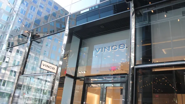 Clothing storefront as seen from outside with plate glass reflecting the street