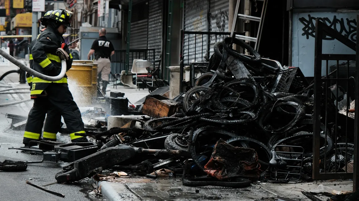 New York City firefighters outside a building after a fire in an e-bike repair shop.