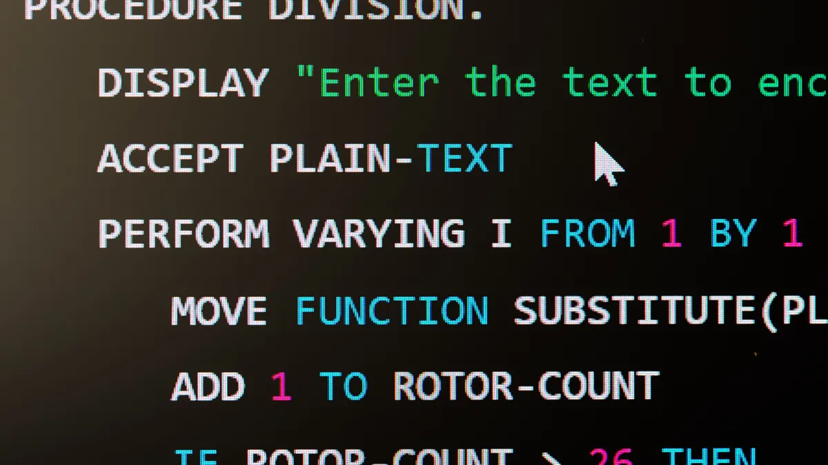 A computer screen displays a snippet of legacy COBOL programming language code.