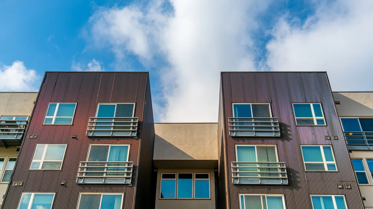 The top of a brown high-rise apartment building.