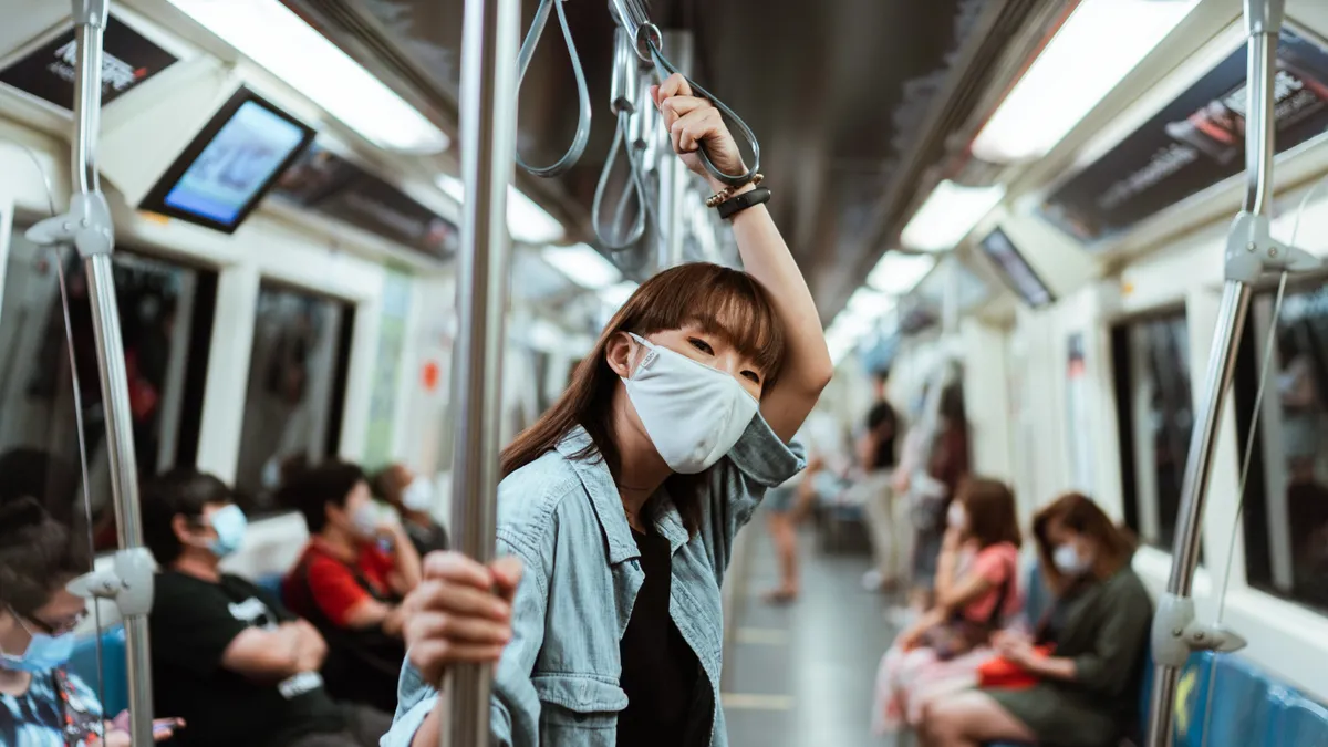 An Asian person wears a medical mask on the train