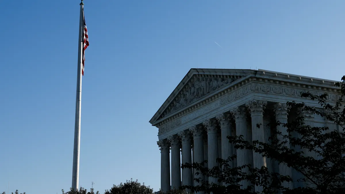 A side-view of the Supreme Court building with a view of a raised flag pole