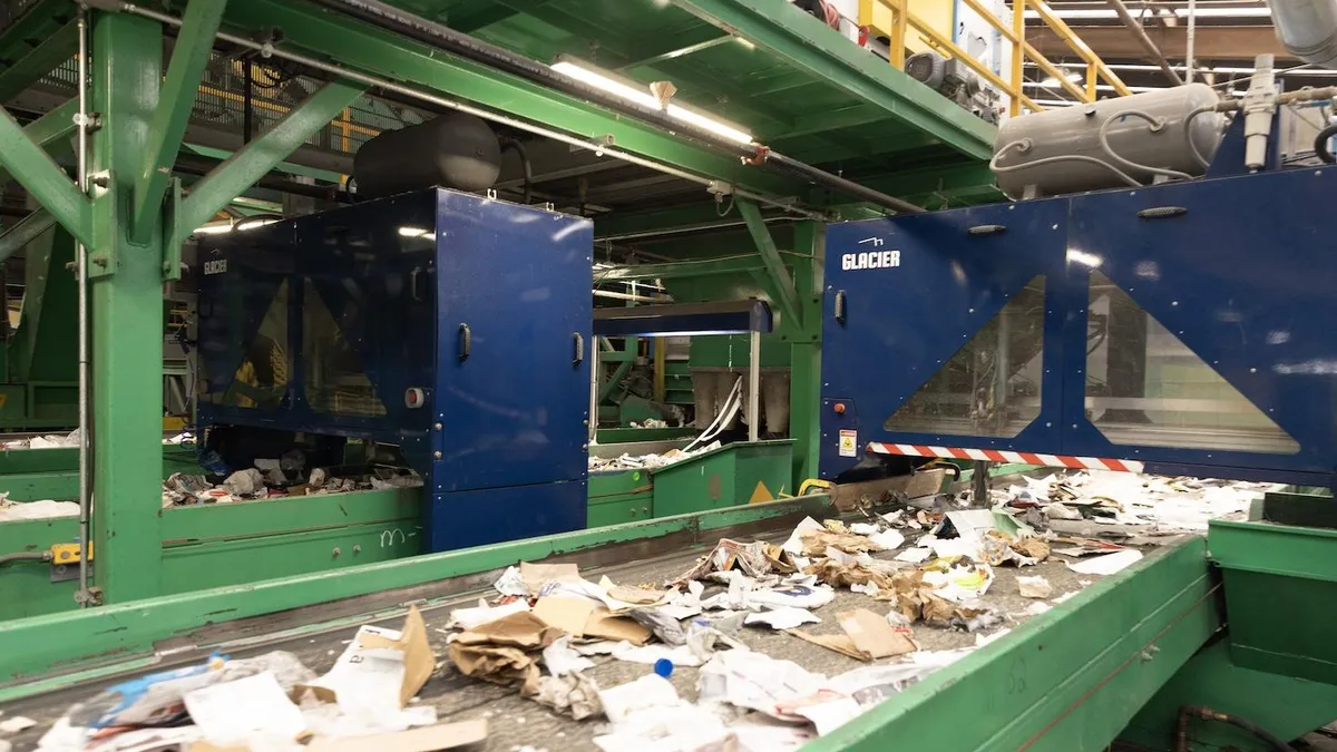 Recyclable material moves on a belt toward a sorting robot made by Glacier