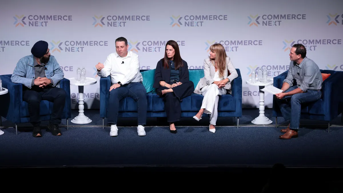 A group of panelists seated on a stage, actively in discussion.