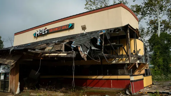A photograph of a damaged restaurant with Moe's Southwest Grill signage.