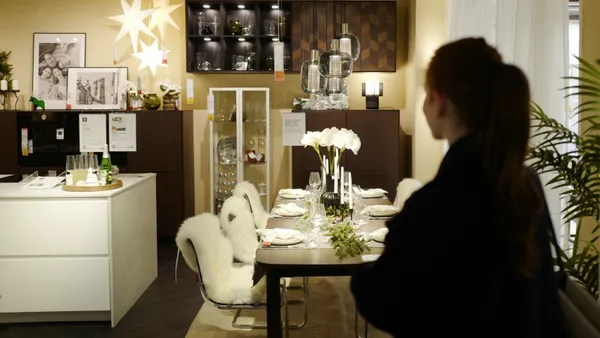 A woman looks at a dining room display in Ikea.