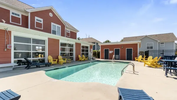 View of a pool with two-story housing in the background.