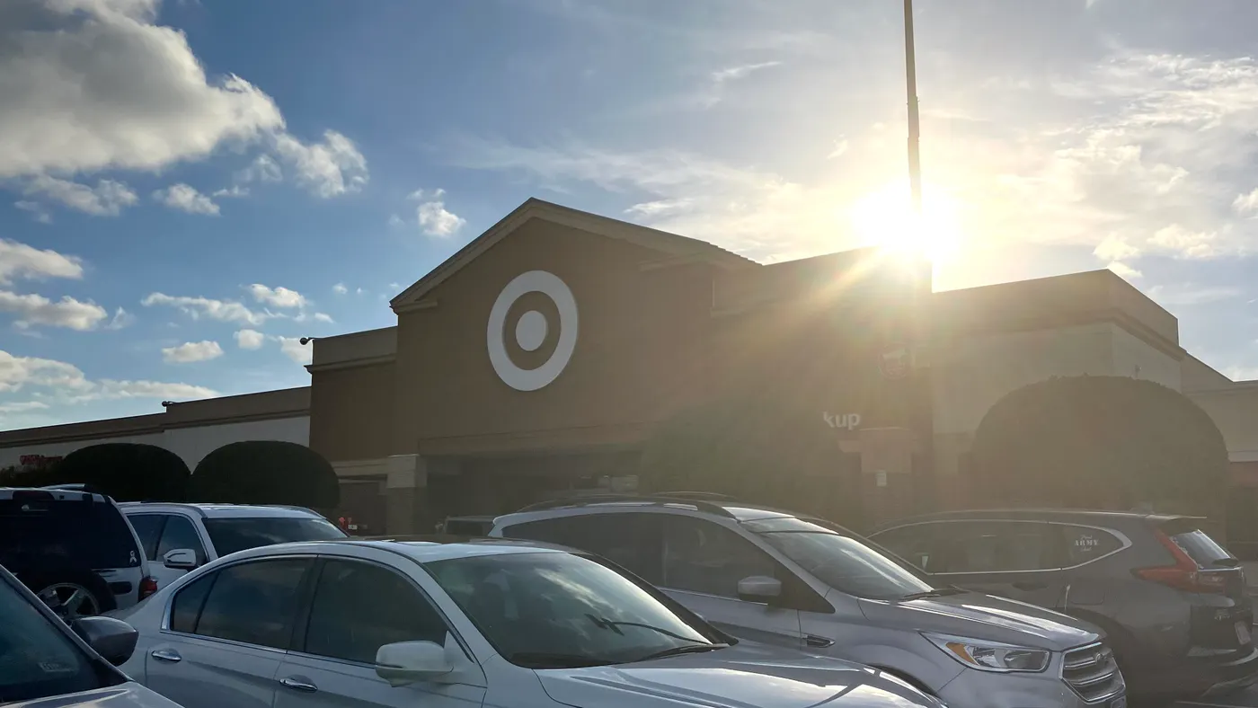 Target's bullseye logo on a storefront with cars in the parking lot